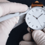 orologio da polso che viene pulito con una piccola pezza da orologiaio con guanti monouso